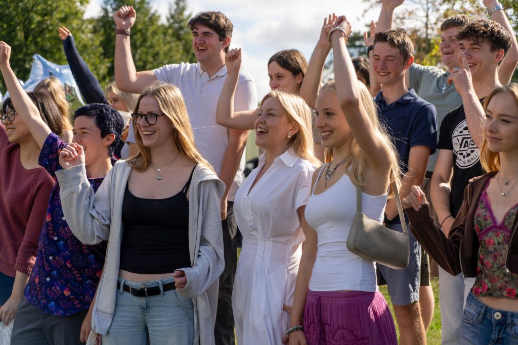 Group of happy students cheering with principal, Sara Russell. Group of happy students cheering with principal, Sara Russell.